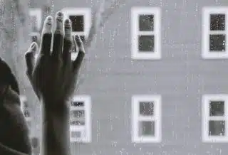 grayscale photo of woman right hand on glass